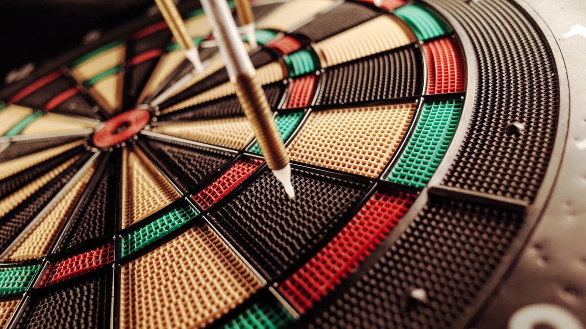 A detailed close-up of an electronic dartboard, showcasing vibrant colors and precision darts hitting the target.